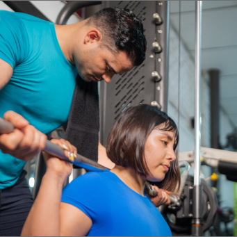 personal-trainer-assisting-determined-woman-liftin-2024-11-21-23-33-22-utc@2x